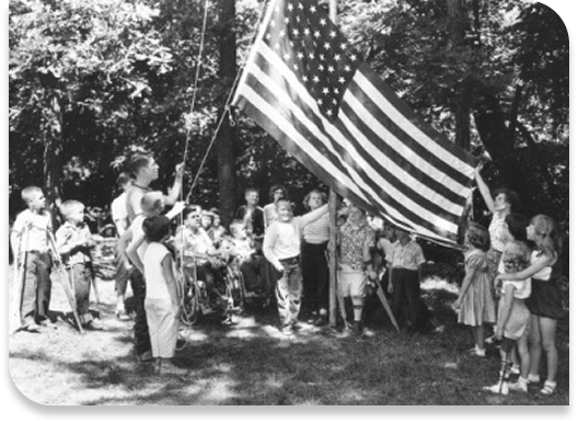 black and white photo of group waving american flag in the air