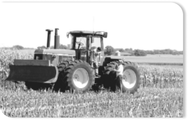 black and white photo of a tractor out in a field