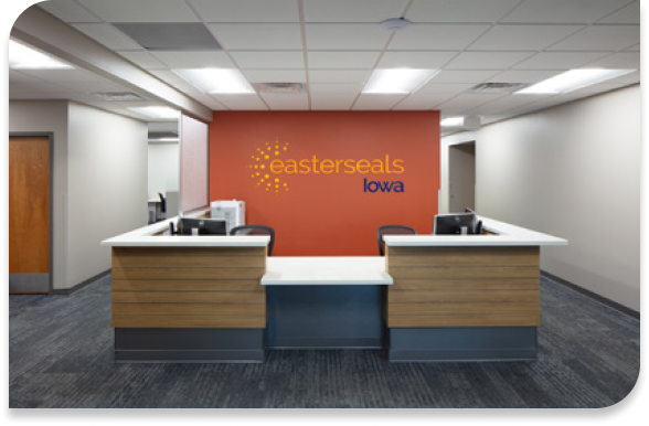 Office photo with orange wall and 90 degree couches facing each other with a coffee table in the middle